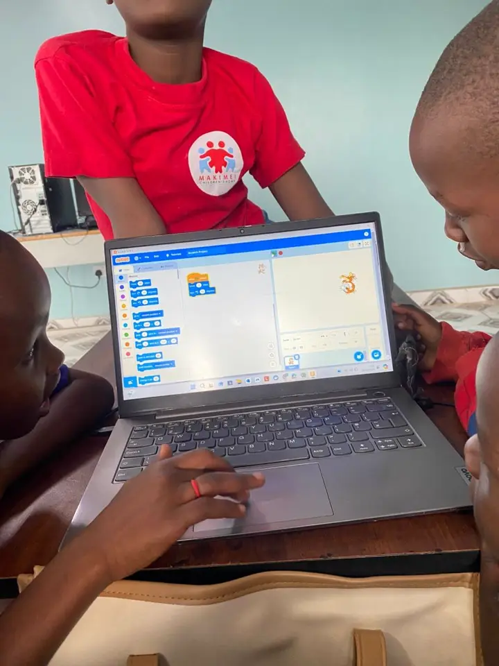 A pupil building a program in Scratch on a laptop